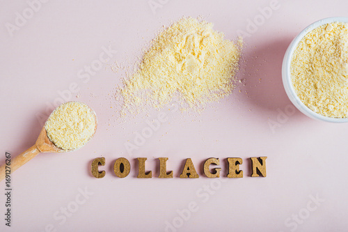 Close up of collagen powder in a bowl and spoon and a glass of water on the table top view