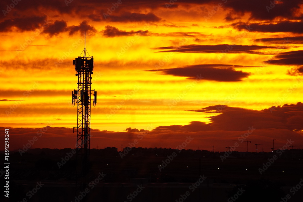 Fototapeta premium Telecommunication tower at sunset with dramatic sky
