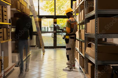 Canvas Print Blurred figures represent workers moving quickly in a small scale warehouse, symbolizing the routine of inventory, cargo preparation and e-business dispatch within logistics operations