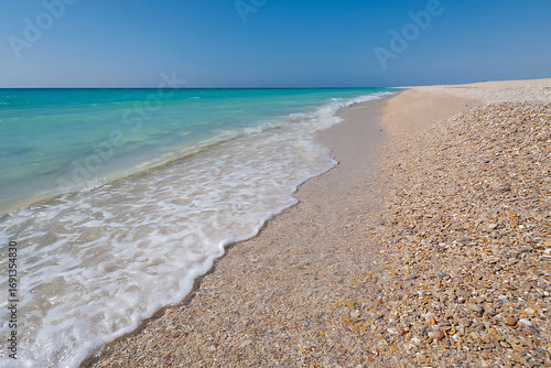 Sunny beach with waves and blue sea, perfect for a tropical vacation