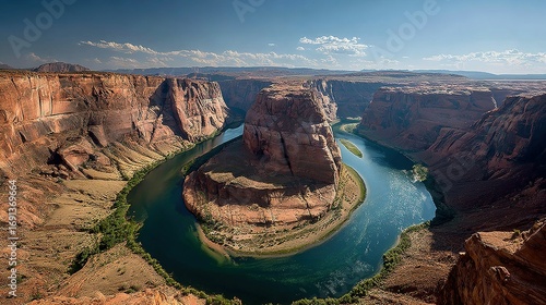 River curves through canyon with cliffs and blue sky on a sunny day.