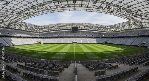 Expansive football stadium with lush green field and seating under a unique roof structure