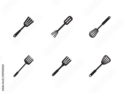 Collection of kitchen utensils on a clean white background featuring forks spatulas and a whisk showcasing culinary tools and equipment for cooking