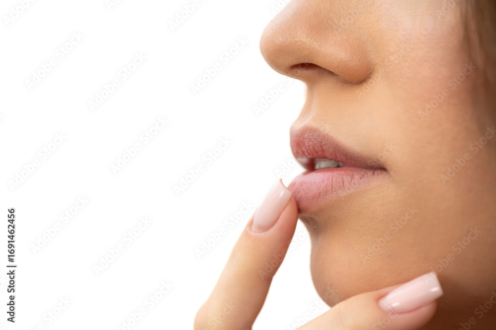 Obraz premium Young woman touching her dry lips, close up. Skin care and lip care concept. Selective focus.