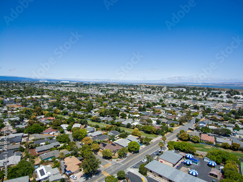 aerial view of a suburban landscape with residential neighborhoods, office buildings, and a distant mountain range in Santa Clara California USA