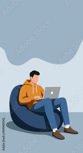Young man working or studying remotely on a laptop while comfortably sitting on a bean bag chair. Ideal for concepts of flexible work, education, or modern lifestyle.