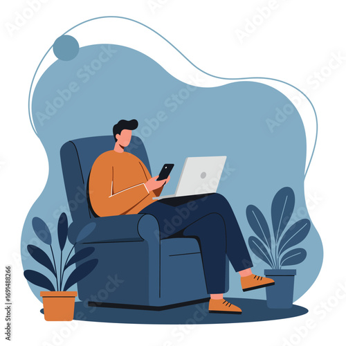 Young man comfortably working or relaxing at home in an armchair, using a laptop and smartphone. Represents remote work, digital communication, and modern lifestyle.