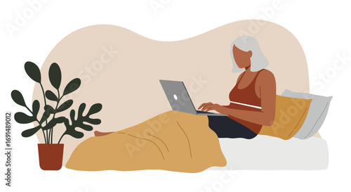 Mature woman working comfortably from bed with a laptop, embodying remote work, home office, or casual online communication. Ideal for lifestyle and technology concepts.