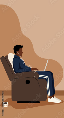 Young Black man in a recliner, wearing earphones and working on a laptop at home. Represents remote work, online learning, or leisure with technology in a cozy setting.