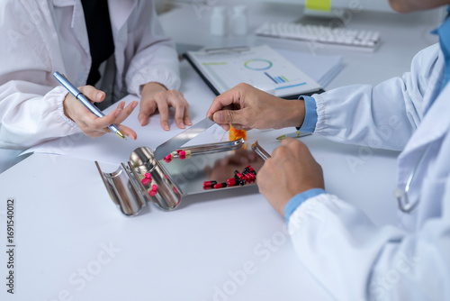 Papier peint Pharmacists counting and sorting capsules in pharmacy or laboratory