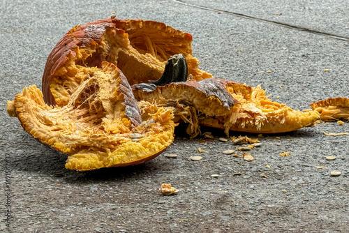 Smashed pumpkin lies in pieces on pavement