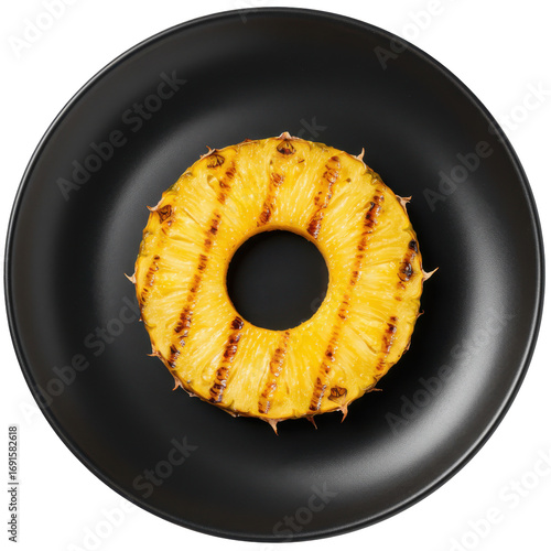 Grilled pineapple ring on matte black plate top down view isolated on white background