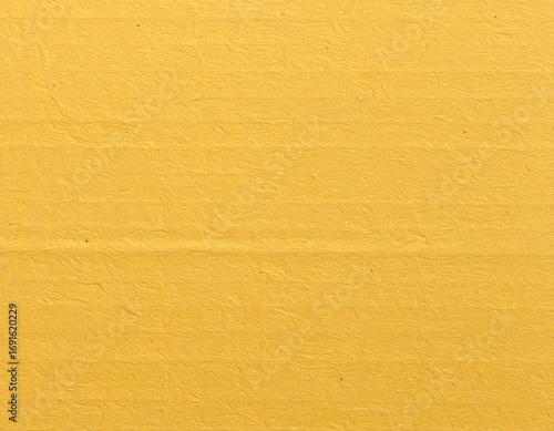 Close-up of a vibrant yellow cardboard surface