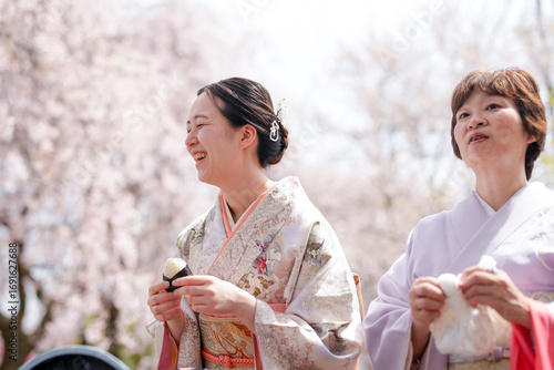 Quadro su tela Two women in kimonos are smiling and eating something