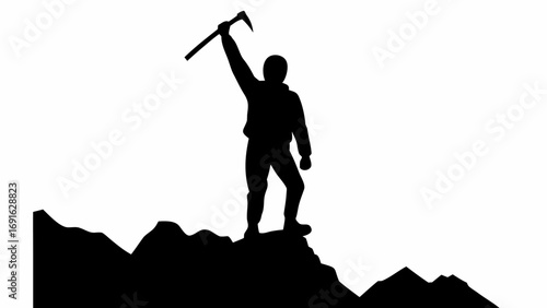 Silhouette of a person on a mountain peak holding an ice axe in the air celebrating the summit achievement