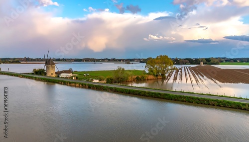 Floodwaters inundate farmland, windmill stands