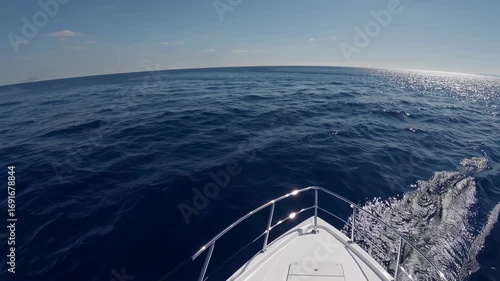 Calm blue ocean view from a boat during sunny afternoon with gentle waves and clear sky