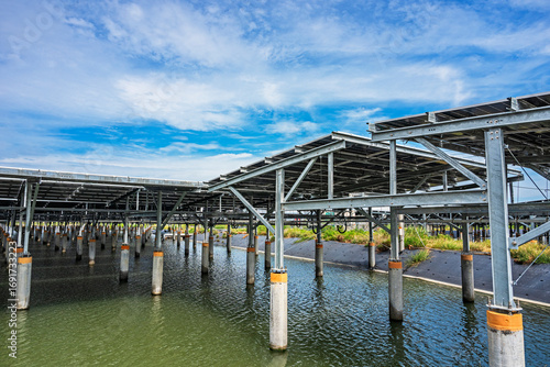 Solar panels stand above a fish pond, combining aquaculture with clean energy.