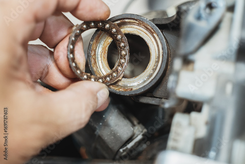 Mechanic check and replace Motorcycle wheel bearings , working in garage . repair and  maintenance motorcycle concept .selective focus