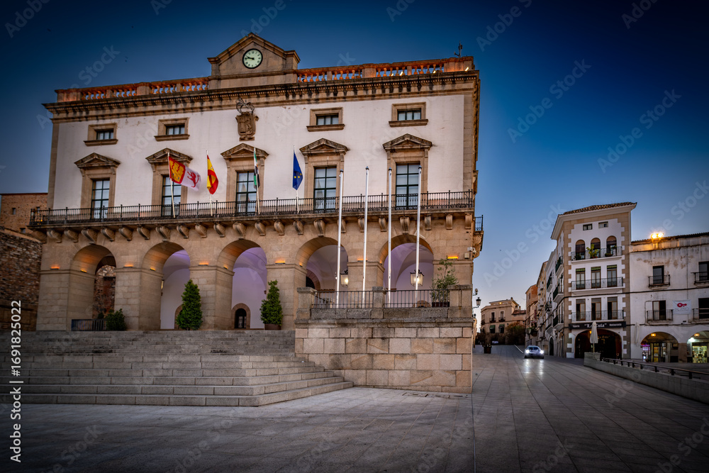 Fototapeta premium Vista panorámica del casco histórico de la ciudad española de Cáceres con vistas a los tejados de tejas marrones de edificios antiguos alrededor de la plaza principal en el soleado día de verano