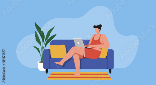 Relaxed individual working on a laptop from a comfy blue sofa at home, ideal for showcasing remote work, modern lifestyle, or freelance concepts.