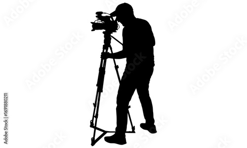 Silhouette of a professional cameraman operating a video camera on a tripod, capturing footage for a production.