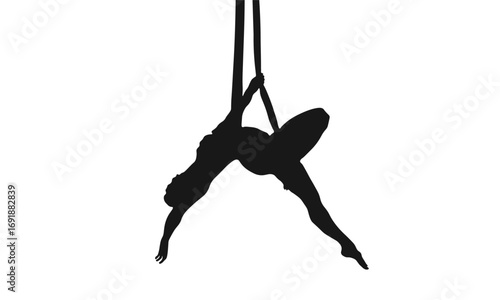 Silhouette of a woman performing aerial silks, suspended in the air.