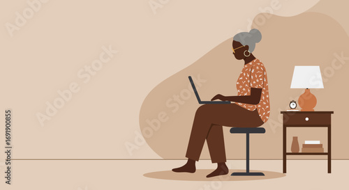 Senior Black woman working on a laptop at home, embracing technology for remote work, learning, or staying connected in a cozy, modern environment.