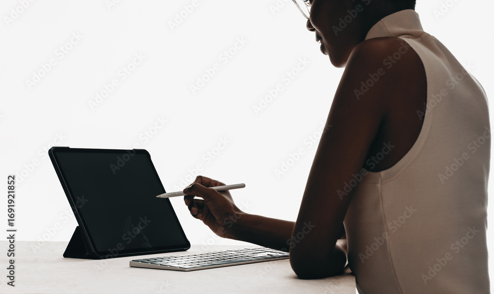 Naklejka premium Professional woman using a stylus with a tablet and keyboard