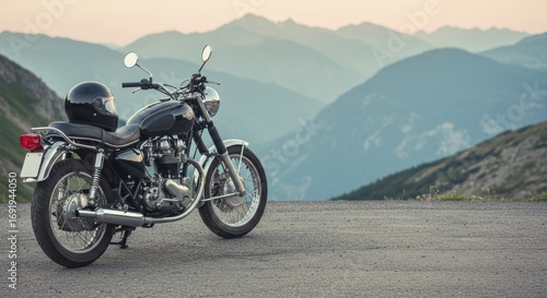 Vintage motorcycle parked on a mountain road with scenic mountain view