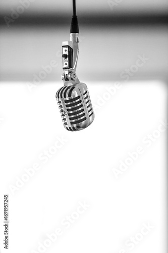 An old school microphone hanging from the ceiling - monochrome - vertical