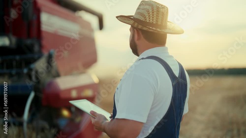 Modern harvesting machinery working in agricultural fields, farmer controlling. Harvest season in farmland, crop picking, modern technology and innovation in agribusiness, economy development