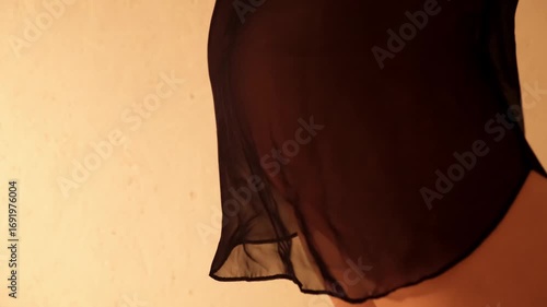 Female buttocks in black transparent chiffon negligee close-up side view. An unrecognizable woman dancing a seductive erotic dance. Sexy slim toned body. Concept of arousal. An exciting temptress. 4K.