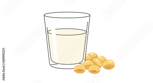 A glass of soy milk next to some soybeans.