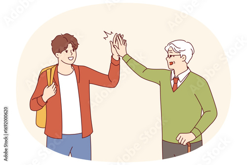 Intergenerational friendship between teenager and old man high-fiving each other as sign of solidarity. Intergenerational friendship between gray-haired grandfather with crutch and grandson