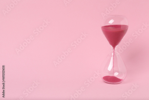 hourglass on a pink background
