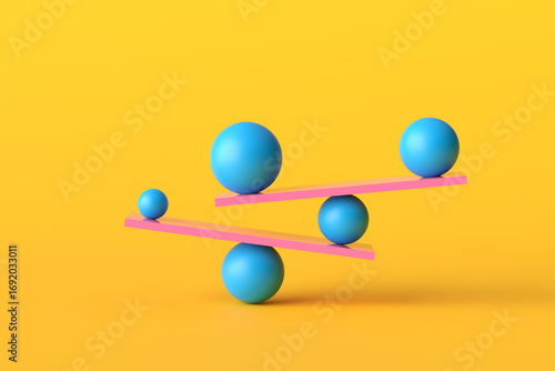 Fotografie Balancing balls of different sizes on pink seesaws creating equilibrium