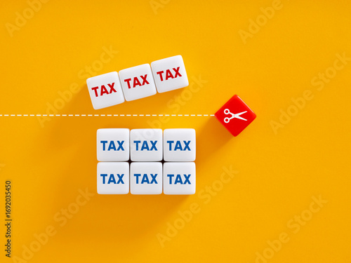 Fotografie Scissors separating high taxes from low taxes on yellow background
