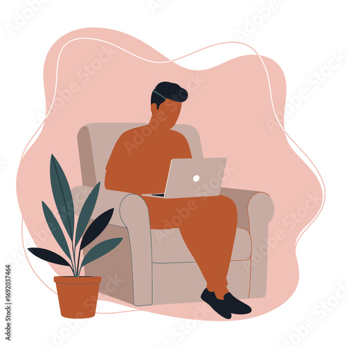 Young man working comfortably on his laptop from an armchair at home. Ideal for concepts of remote work, freelancing, online education, or modern digital lifestyle.
