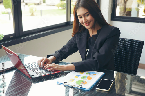 Business and Financial Planning Concept. Financial advisor planning and working on laptop. Happy Professional Businesswoman, typing and review annual report at home office.