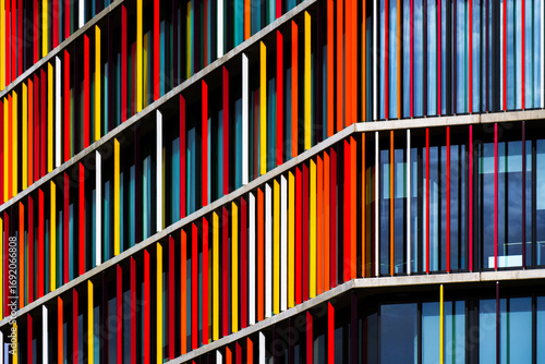 Vibrant office building façade with colorful vertical panels creating rhythm, contrast, and dynamic architectural composition.