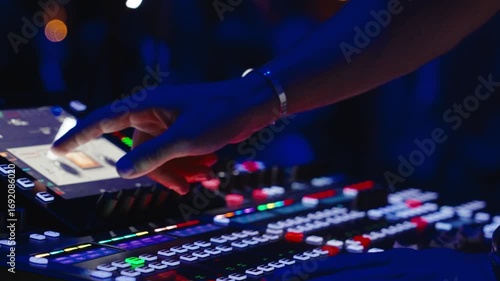 Professional sound engineer adjusting levels on a digital audio mixer during a christian worship night, ensuring high-quality sound for the audience