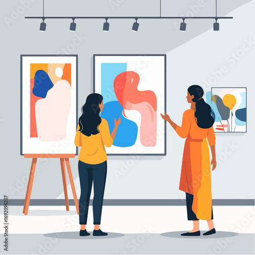 Abstract paintings on display in a modern art gallery, with two women viewing the artworks, illuminated by track lighting in a spacious, minimalist environment.