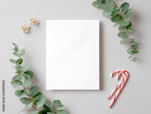 Joyful sustainable christmas greeting card mockup on white background. flat lay invitation with eucalyptus branches offers simple festive and natural holiday design