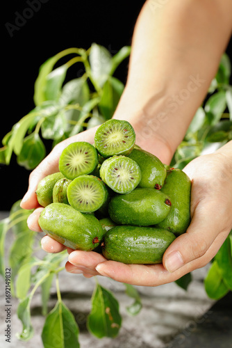 Fresh Mini Kiwi Fruits in Hands - Organic Green Berries with Natural Heart Pattern