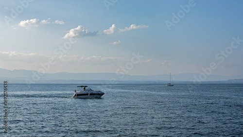 Plaisanciers dans leur bateau à moteur de croisière faisant du tourisme en naviguant sur le lac Léman en fin de journée de vacances en été.