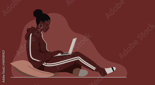 Young Black woman comfortably working or studying on a laptop at home, embodying remote work, online learning, and a relaxed lifestyle.