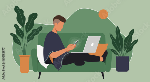 Young man working remotely from home, multitasking with a laptop and smartphone on a comfortable sofa. Illustrates modern digital lifestyle and flexible online work.