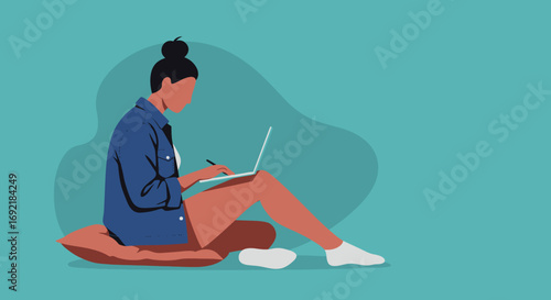 Young woman focused on remote work or study, sitting comfortably on a pillow with a laptop and pen. Ideal for themes of productivity, digital learning, and modern lifestyle.