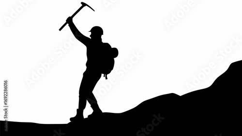 Silhouette of a mountain climber with ice axe and backpack on a mountain peak in black and white image